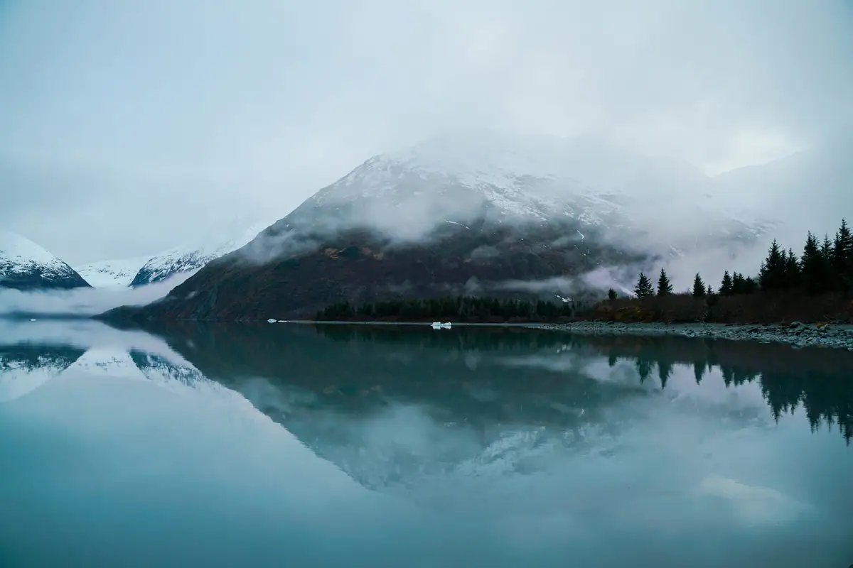 A calm mountain lake under a muted sky
