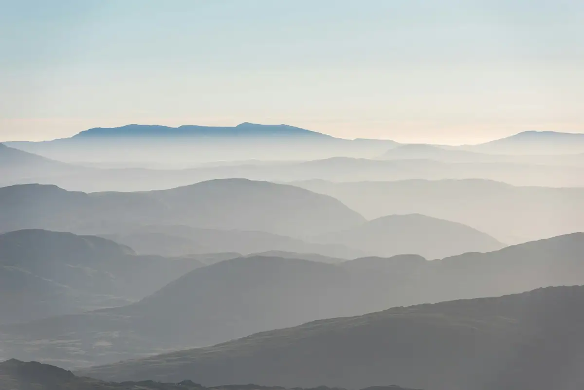 Muted mountain ridges receding into mist